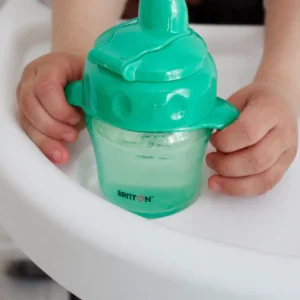 Close-up of a child holding the Britton green non-spill cup
