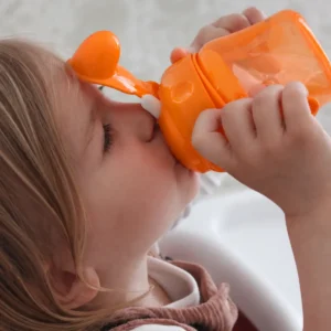 Child drinking from the Britton orange non-spill soft-spout cup