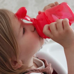 Child drinking from the Britton red non-spill soft-spout cup
