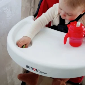 Britton red non-spill cup on a high-chair tray