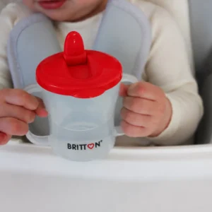 Child holding the Britton First Cup 200 ml red